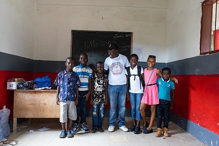 Candid shot of students and caretaker standing in a room shot by ashish gurbani best photographer based in mumbai india.