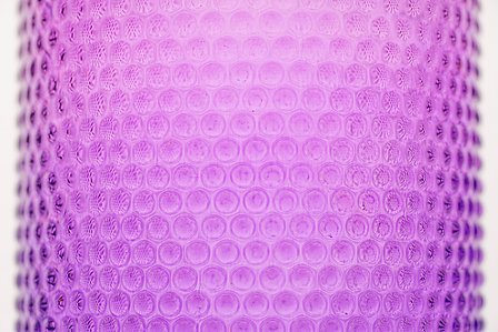 a close up photograph of a pink transparent bottle professionally shot in a studio setting with a white background taken by best creative photographer ashish gurbani based in pune india