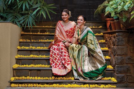 two female models wearing stunning sarees and enjoying a moment of festive joy for diwali branding advertising shoot  by best Indian saree photographer  based in pune