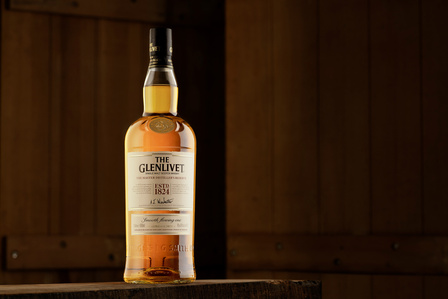 the glenlivet kept in on a wooden barn setup created in a studio lighting setup on broncolor lighting systems by the best luxury product photographer specialising in whiskey bottle photography based in mumbai india