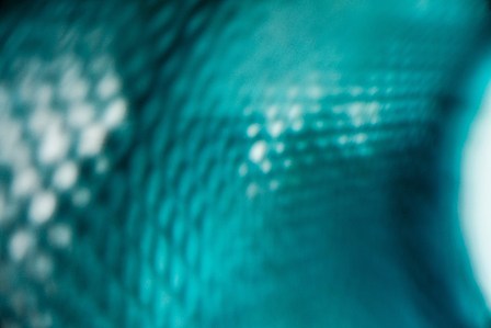a professional close up photograph of a blue transparent bottle shot in a studio setting by leading commercial photographer ashish gurbani based in pune india