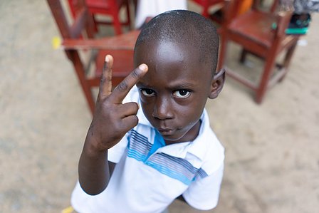 Young boy showing a victory symbol to the camera shot by Ashish Gurbani top travel photographer based in Mumbai India.