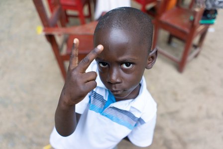 Young boy showing a victory symbol to the camera shot by Ashish Gurbani top travel photographer based in Mumbai India.