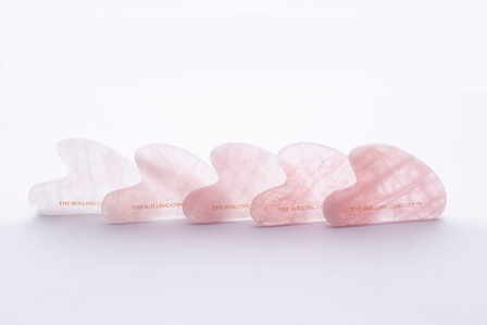 a high key shot of rose gua shas lined up to form a beautiful gradation in a studio lighting setup photographed by leading cosmetics photographer based in Mumbai India
