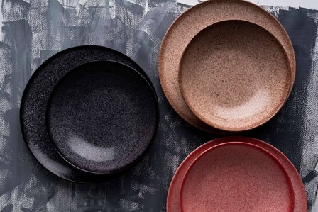 trio colors of porcelain plates on a gray painted paper background photoshoot with best advertising photographers based in mumbai india