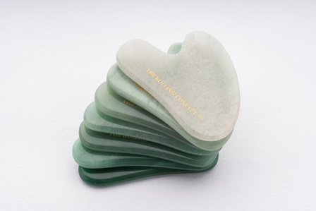 a stack on gua shas on a white background showcasing the shades of jade shot by luxury product photographer based in Pune and mumbai india