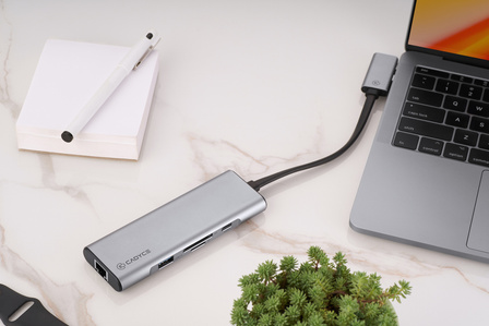 a beautidful type c convertor of best quality for apple macbook pro kept on a desk with notepad and plant in a studio lighting setup by best product photographer specilising in technology brands