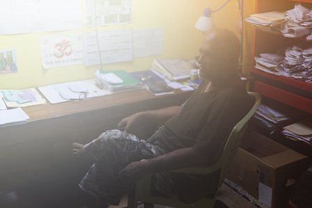An elderly man engaged in deep thoughts sitting beside his study table shot by Ashish Gurbani top photographer based in Mumbai India.