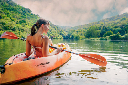 A beautiful girl spending some time practicing kayaking on a Westin goa boat amidst a deep green jungle lake shot by one of the best lifestyle photographers based in Mumbai India.