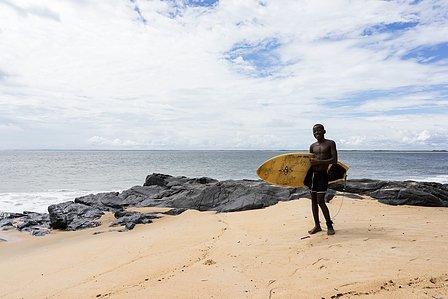 Young boy about to go surfing, posing with a surfboard on the beach shot by Ashish Gurbani top fashion photographer based in Mumbai India.