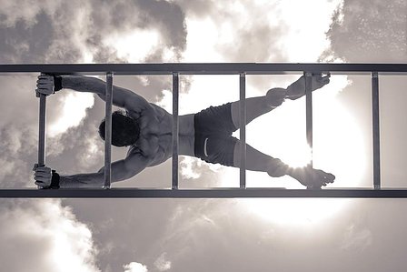 conceptual black and white photoshoot of fitness model posing on ladder doing yoga pose shoot with leading advertising photographer specialising in fitness photography based in mumbai india