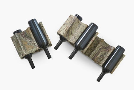 black bottles placed on a stone bottle luxury holding stand soht by local photographer