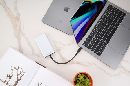 leading technology photoshoot of a type c to usd convertor for apple laptop shot on white marble slate with book and planter on the table by best still life photographer based in pune india