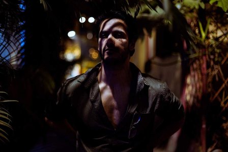 a male model posing under street light forming tree shadows on face, professional photoshoot taken by top fashion photographer ashish gurbani based in mumbai india