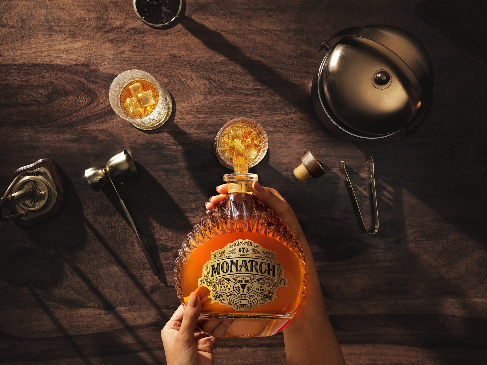 a top down shot of a whiskey bottle pouring liquid into a glass for advertising brand photography in mumbai india