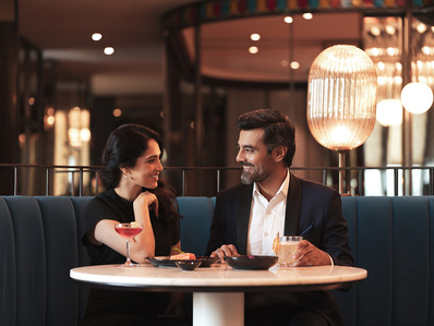 a young couple relaxes in a fine dine restaurant captured by award-winning advertising photographer while waiting for their food