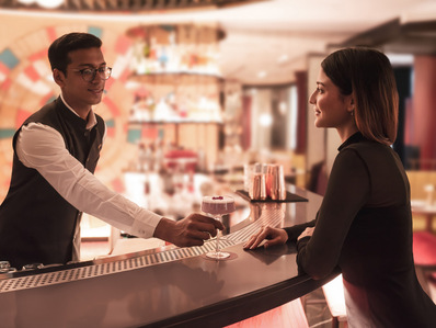 a hospitality photography campaign captures a beautiful girl interacts with the bartender