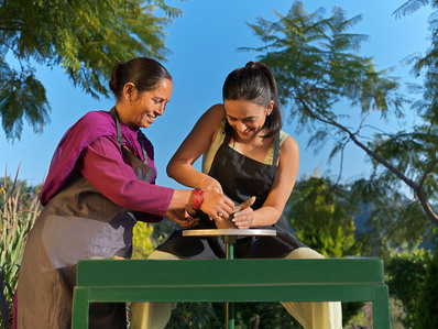 a young charming girl photographed by hotel lifestyle photographer learns pottery in golden light 