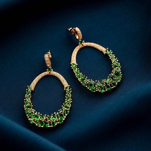 a professional conceptual jewellery shoot of green emeralds on wavy blue cloth shot by best fashion photographer ashish gurbani based in mumbai india