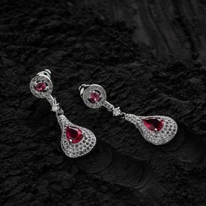black mud background concept photoshoot of earring jewellery with red stones photographed by the best creative jewellery photographer ashish gurbani based in mumbai india