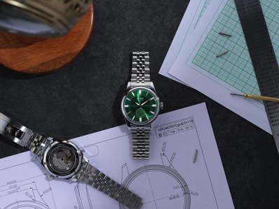 a green dial luxury watch placed on a design table board photographed by the best product photographer in Pune India