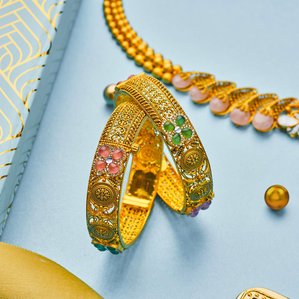 A beautiful photoshoot by jewelry Photography in india of gold bangles studded with rare gems placed in a creative manner showcasing the beauty of the jewellery.