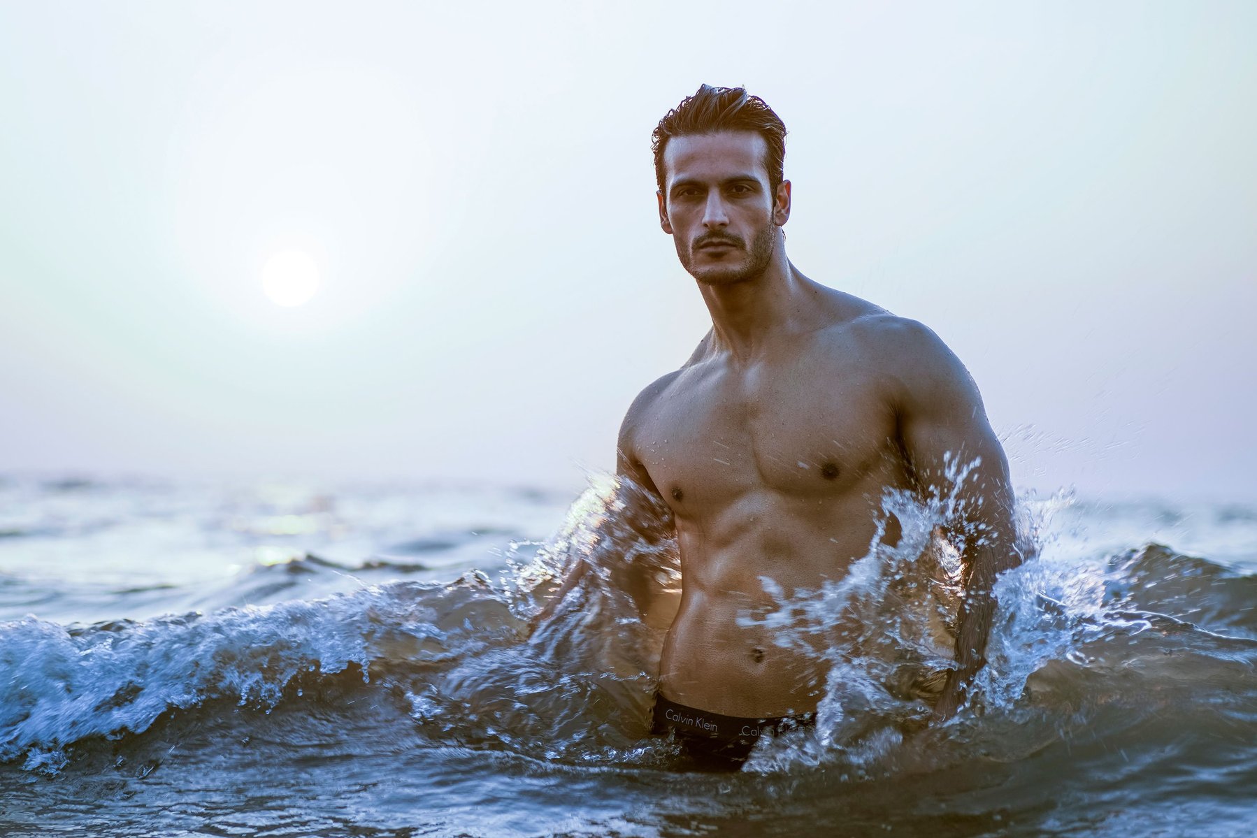 a portrait photograph of fashion model angel singh shot on a beach in the water against the sunset shot by top advertising photographer ashish gurbani based in Mumbai india
