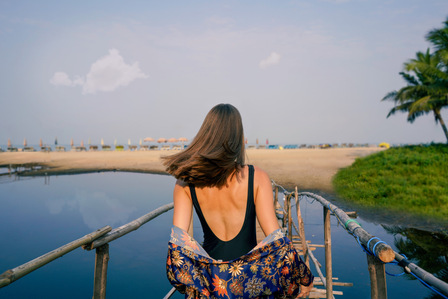 beautiful girl walking on a bridge towards a beautiful clean Goan beach on a warm sunny day for a brand campaign photoshoot for marriott bonvoy with one of the emerging creative advertising photographers based in mumbai india