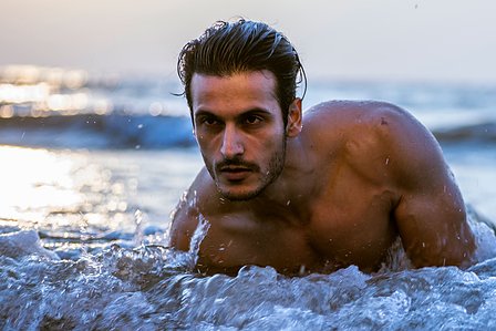 a close up portrait of model angel singh lying down on the beach in the water during sunset shot by best fashion and ad photographer ashish gurbani based in Mumbai india