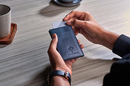 a luxury blue wallet on creative product photography background of table setup at a cafe in mumbai india