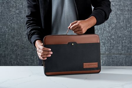 a hand model poses for leading advertising photographer in mumbai with a laptop bag for photoshoot in studio 
