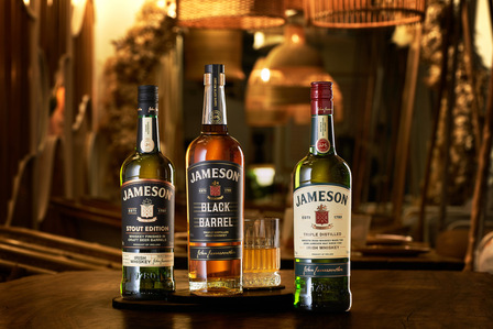 an image of Jameson whiskey bottles displayed on a wooden table in a warm restaurant setting captured by an advertising commercial photographer in Pune, India.