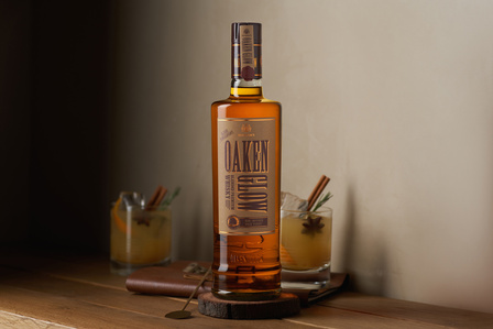Professional product photographer in Pune, India captures a rustic whiskey Bottle with an old fashion cocktail in the background