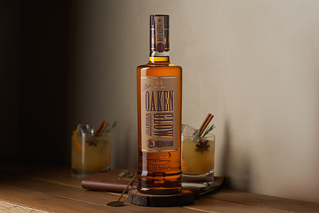 Professional product photographer in Pune, India captures a rustic whiskey Bottle with an old fashion cocktail in the background