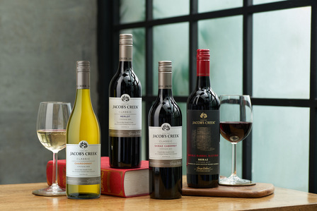 A batch of wine bottles kept on a wooden table near a window was taken by a Professional Product Photographer in Pune, India.