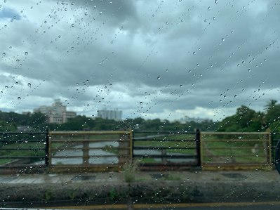 a professional photoshoot taken in an outdoor setting in monsoon climate with water droplets shot through the glass of a car during covid times for photography blog post by best commercial photographer based in mumbai india