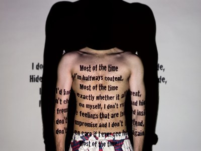 a professional photograph of a male model standing in front of a projector for a concept photoshoot to showcase the need of words more important than face shot by creative advertising campaign photographer based in pune india