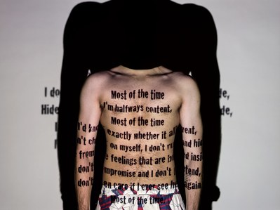a professional photograph of a male model standing in front of a projector for a concept photoshoot to showcase the need of words more important than face shot by creative advertising campaign photographer based in pune india