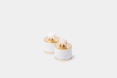 a professional photoshoot in studio with white background of white marble home showpiece containers with golden covers  by creative product photographer specializing in website imagery for digital content creation 