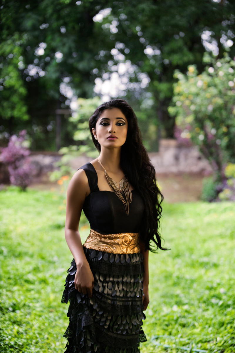 model posing in green forest for the concept based photoshoot in her black designer garment for shoot with best editorial photographer based in mumbai india