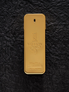 a golden reflective perfume bottle by paco rabanne shot by leading luxury perfume photographer based in pune