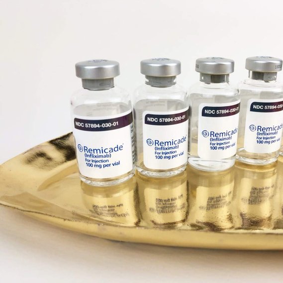 zoomed in view of a shiny gold platter with medical vials of remicade placed on top of it