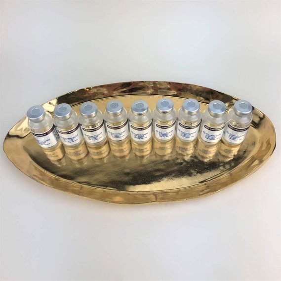  a shiny gold platter with 9 medical vials of remicade placed on top of it