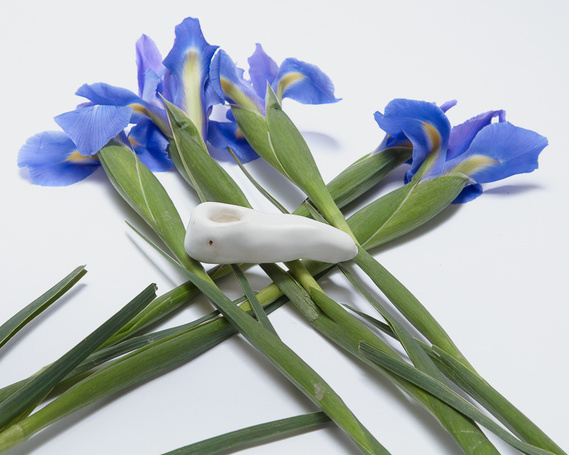 a white pipe glazed in marshmallow sits on a bed of violet flowers