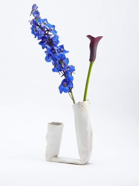 a double vessel in marshmallow, with two silver hoops, that has two purple/blue flowers in the right side