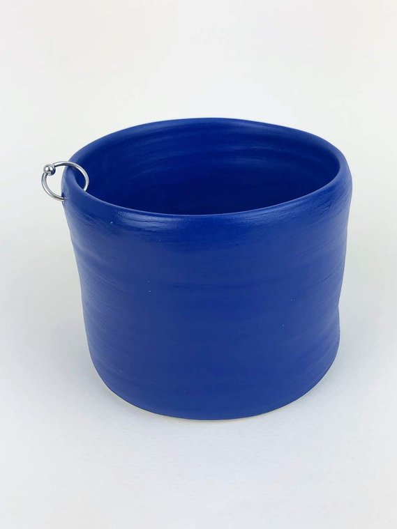 a royal blue plant pot with a silver hoop piercing the side