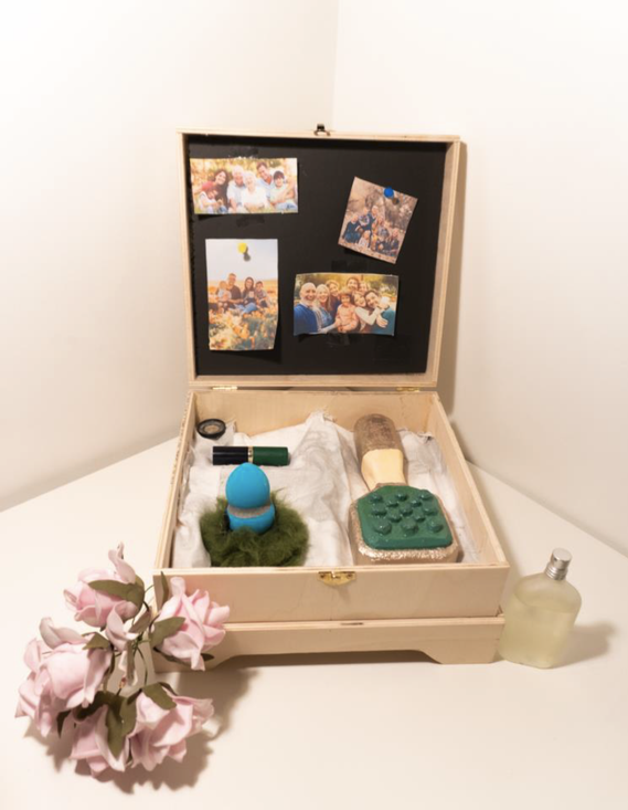 Image depicting the open self care kit, containing hairbrush, powder puff and lipstick.