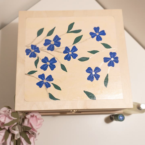 Image of the dementia sensory kit closed, viewing the wooden box’s top, decorated with flowers.