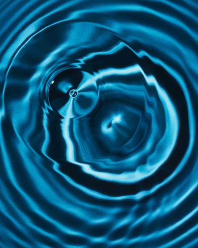 Close-up image of water dripping on blue background.