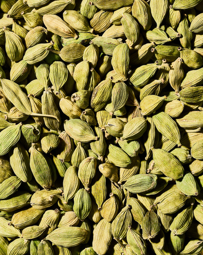 Close-up image of dried green cardamom seeds.